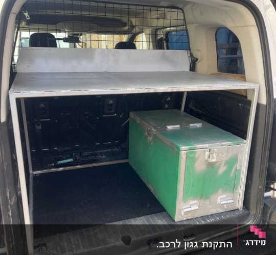 מסגרת מתכת בתא מטען של רכב עם ארגז ירוק